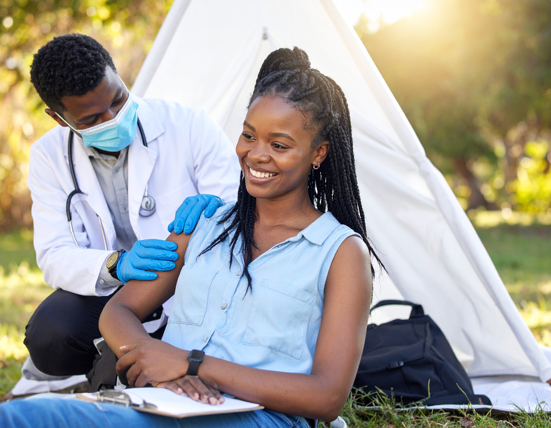 Healthcare professional providing medical treatment to employee in wellness tent